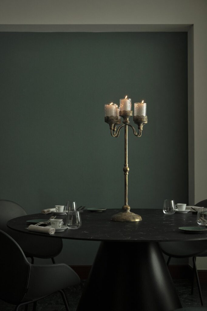 Tavolo apparecchiato con candelabro nella sala del ristorante La Caprese di Mozzo